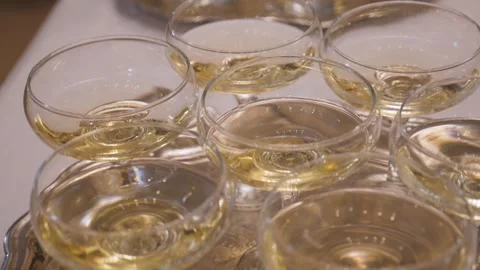 An array of crystal wine glasses carefully arranged on a white linen tablecloth Stock Footage 267581381