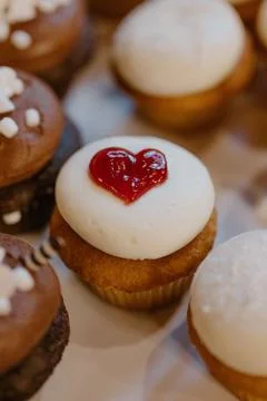 Array of delicious desserts with a heart-shaped topping arranged on a white plat Foto stock