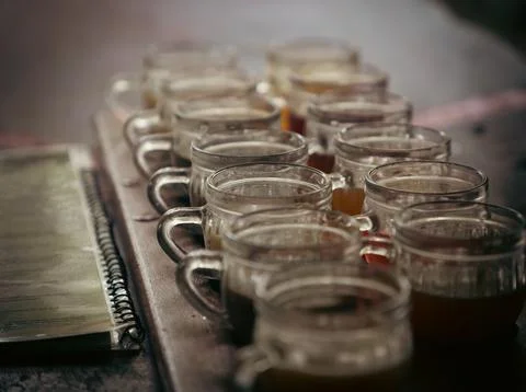 Array of glasses filled with various beverages lined up neatly on a tabletop Foto stock
