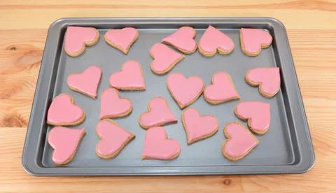 Array of heart-shaped cookies with pink frosting Foto stock