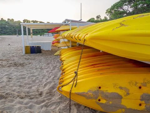 Array of kayaks stacked atop one another against a backdrop of a tranquil lake Stock Photos