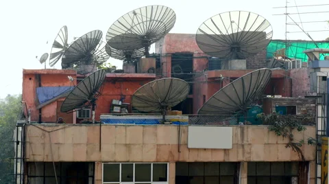 An array of large satellite dishes sit atop a skyscraper in central New Delhi Stock Footage 51520887
