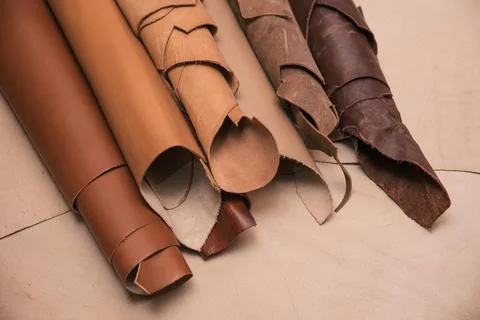 Array of leather fabric samples in different shades neatly placed on a table, re Foto stock
