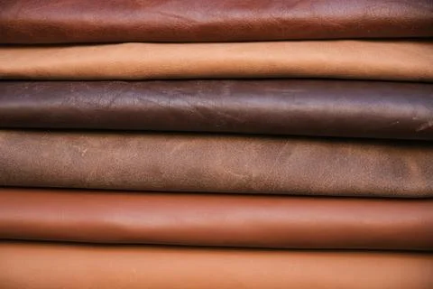 Array of leather fabric samples in different shades neatly placed on a table, re Stock Photos