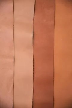 Array of leather fabric samples in different shades neatly placed on a table, re Foto stock