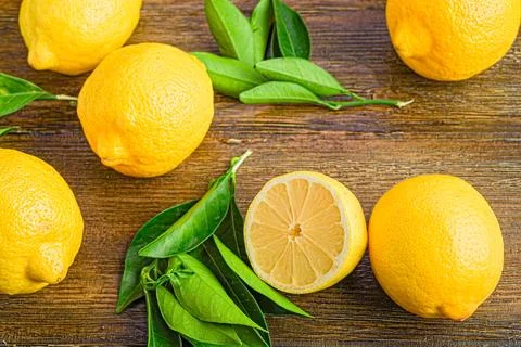 Array of lemons on an antique, dark wooden table. Fotos de archivo