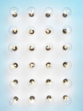 Array of lit incandescent tungsten light bulbs on blue background Stock Photos