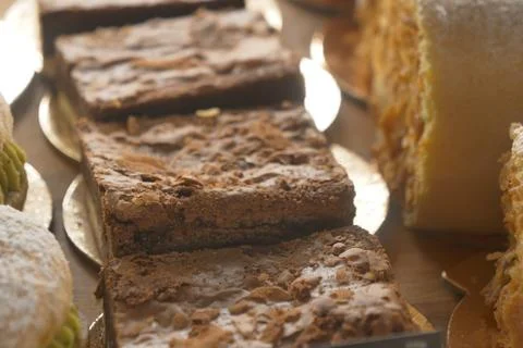 An array of pastries and eclairs are presented in the bakery display case with 스톡 사진