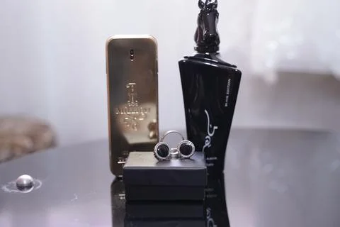 Array of perfume bottles displayed on a transparent glass table Stock Photos