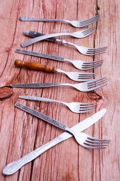 Array of rustic forks and a single knife Stock Photos