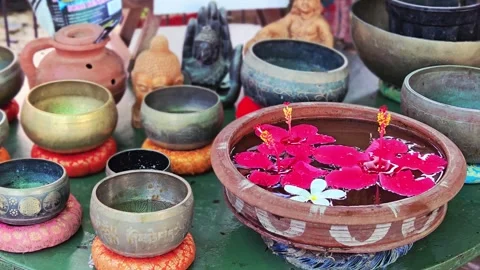 An array of singing bowls and spiritual artifacts sits on a table. A terracotta Vídeo Stock 333611239