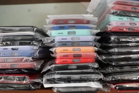 An array of smartphone cases in a variety of colors and designs neatly stacked Stock Photos