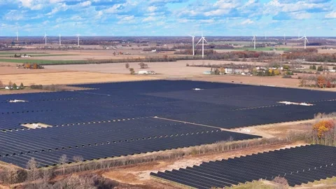 Array of solar panels and wind turbines in Michigan, USA generating clean Stock Footage 329467404