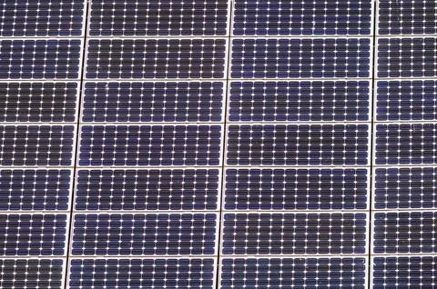 Array of solar panels generating clean energy from sunlight on a rooftop Stock Photos