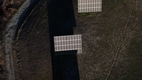 An array of solar panels situated in a dry, grassy field, highlighting the Stock Footage 332480431