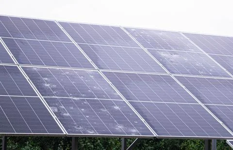 Array of solar panels with visible hail damage and water spots, highlightin.. Stock Photos