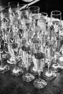 Array of sparkling crystal glasses filled with champagne atop a rustic wooden ta Stock Photos