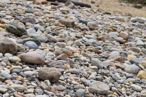 Array of stones and pebbles in a tranquil beach setting Stock Photos