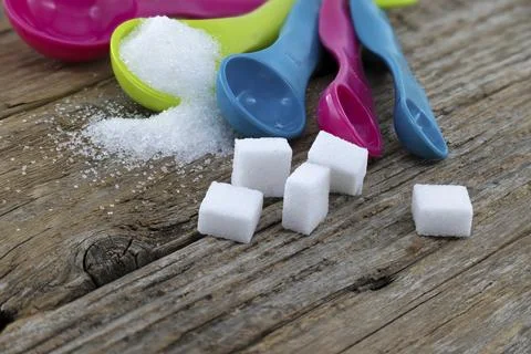 Array of sugar presentations on a wooden table, showcasing sugar cubes and Stock Photos