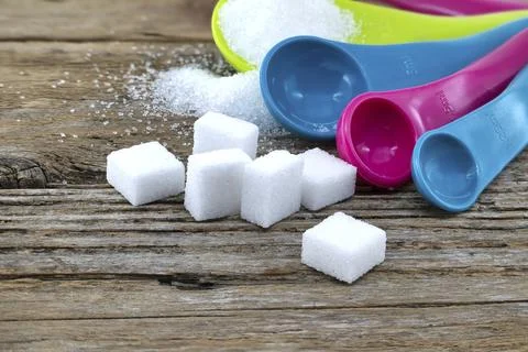 Array of sugar presentations on a wooden table, showcasing sugar cubes and Stock Photos