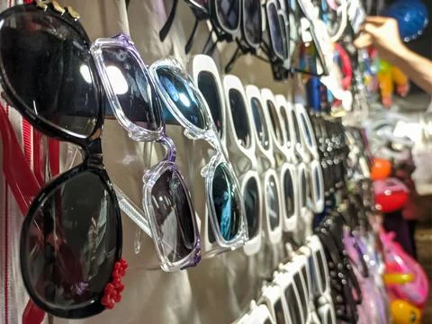 Array of Sunglasses Displayed on a Rack at a Shopping Market Stall Stock Photos