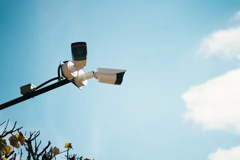 An Array of Surveillance Cameras Positioned Against a Clear Blue Sky Above Us Stock Photos