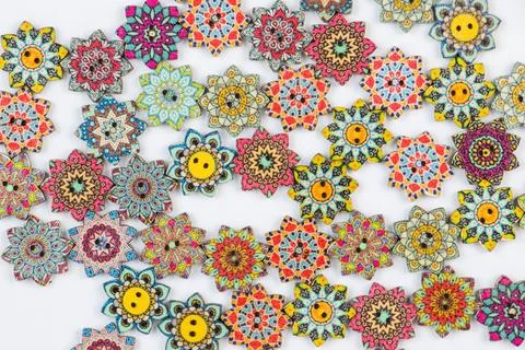 Array of vibrant colored ornamental buttons artfully arranged against a white ba Stock Photos