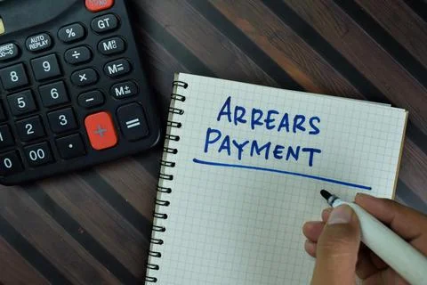 Arrears Payment write on a book isolated on Wooden Table. Fotos Stock