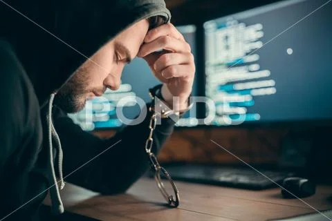 Arrested hacker criminal in handcuffs got caught, cyber crime punishment Stock Photos