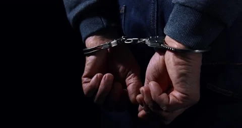 Arrested man with cuffed hands behind back Video stock 168940917