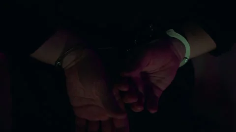 Arrested man. Hands cuffed, illuminated by police flashers. Dark room Stock Footage 306894317