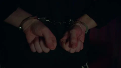 Arrested mans hands cuffed behind his back. Flashing blue and red, close-up. 스톡 동영상 314002247