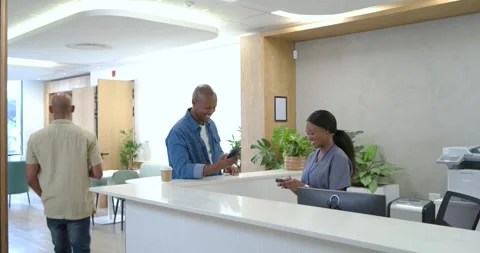On arrival man approaching desk, showing phone for checkin, receiving ID, Stock Footage 342233320