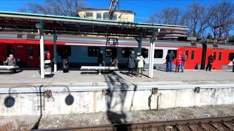 Arrival of a passenger commuter train on the platform of the railway station Stock Footage 172549858