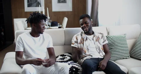 Arrival, welcome handshake. Two young African American men are sitting Stock Footage 134580564