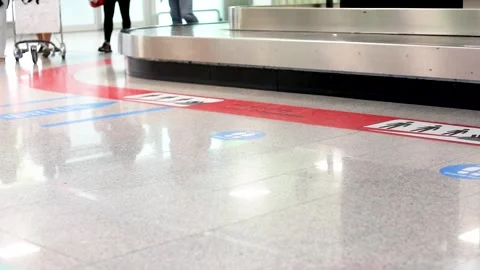 Arriving passengers go to the baggage carousel with carts 動画素材 318513628