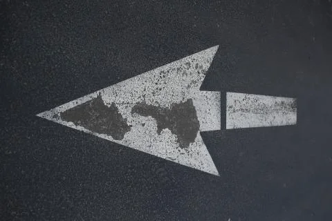 Arrow on asphalt Stock Photos