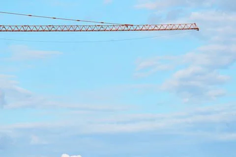 The arrow of the construction tower crane is yellow and orange against Foto stock