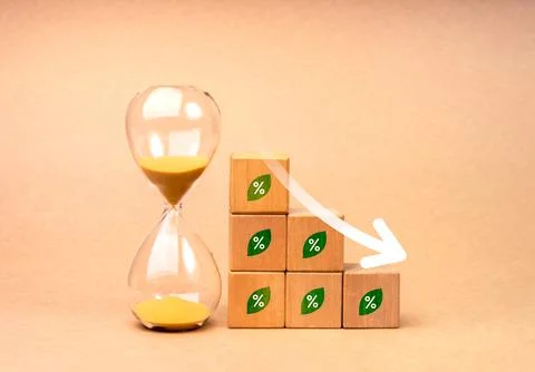 Arrow down on wood cube blocks as graph steps with green leaf with percenta.. Stock Photos