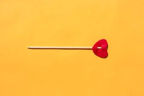 Arrow with a heart on a yellow background. isolate. place for the label Stock Photos