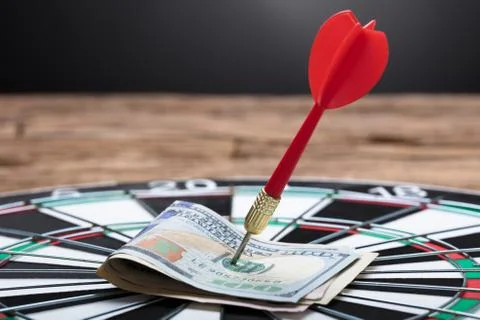 Arrow In Papernotes On Dartboard At Table Stock Photos