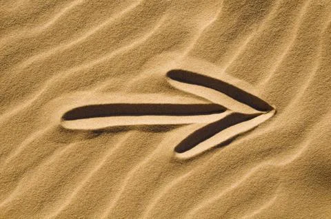 Arrow sign in the sand Stock Photos