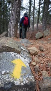 An arrow on the stone indicates the direction of the hiking trail and directi 스톡 사진