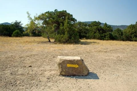 Arrow on a stone, specifying a direction in mountains Stock Photos