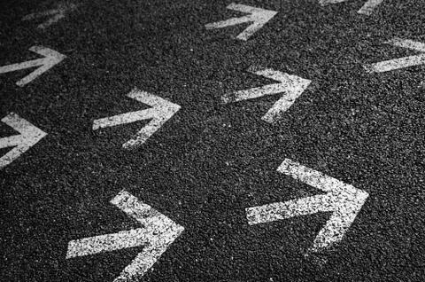 Arrows on asphalt Stock Photos