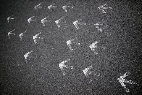 Arrows on asphalt Stock Photos