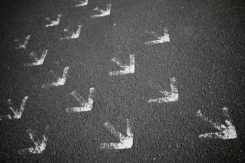 Arrows on asphalt Stock Photos