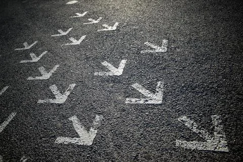 Arrows on asphalt Stock Photos