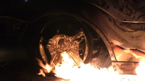 Arson has set a car on fire and gasoline is dripping and burning 库存影片 100938486