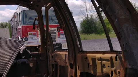 Arson scene with burned out car and fire truck Stock Footage 330983962